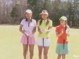 Hübsch asiatisch teenager mädchen spielen ein spiel von streifen golf